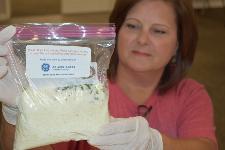 GE Employee hold up bag of dry soup mix prepared for Day of Caring.